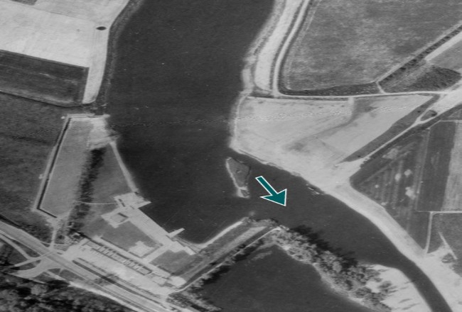 Luchtfoto van een rivier. Links en rechts staan velden. Onder de rivier een voormalige sluis.